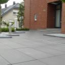 Moderne und pflegeleichte Vorgartensituation. Architektonische rafinesse aus hochwertigen, großformatigen Betonwerksteinplatten, kombiniert mit Formgehölzen in Edelsplittbeeten.